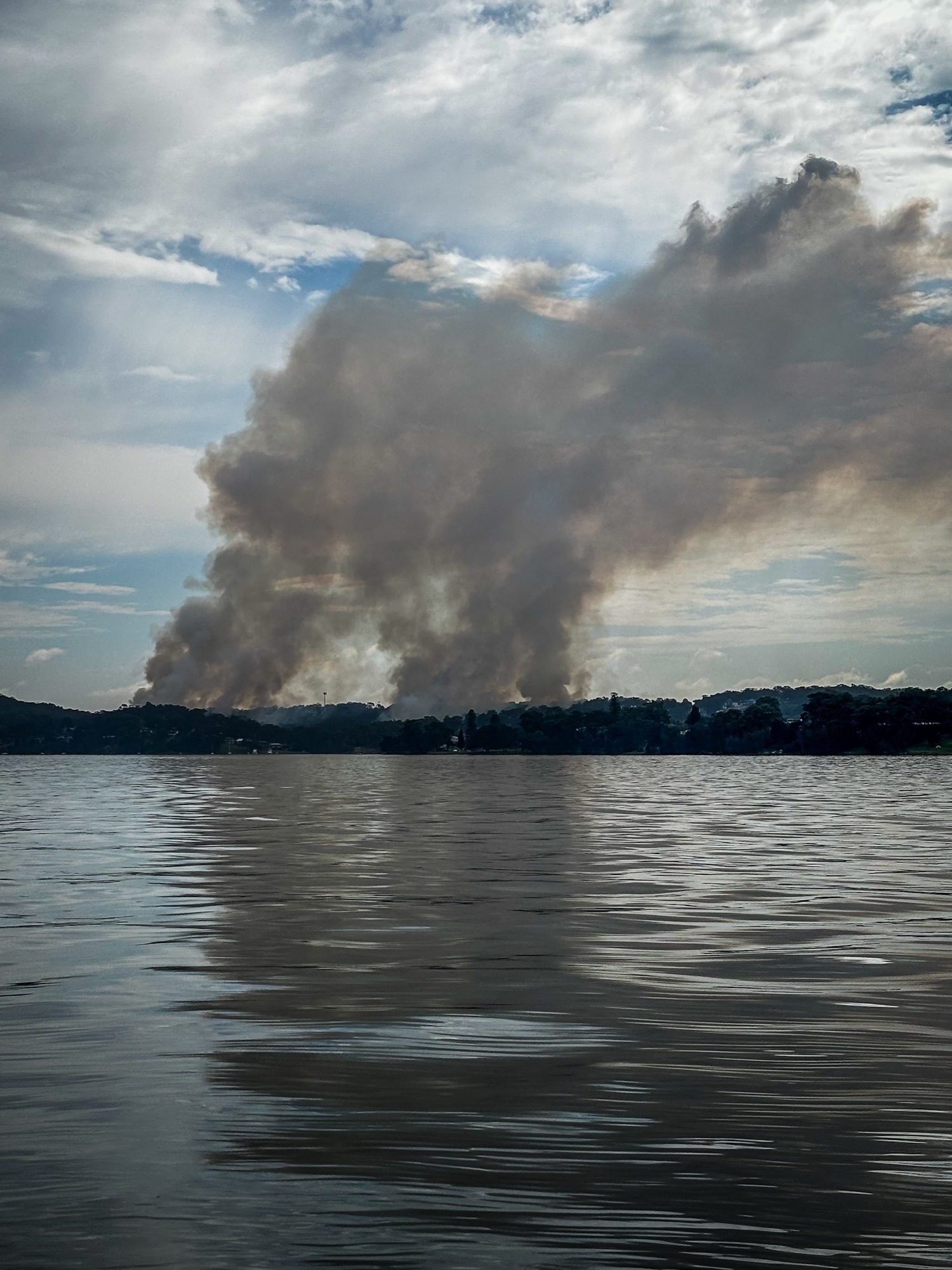 Smoke from a grass fire rising into the sky 